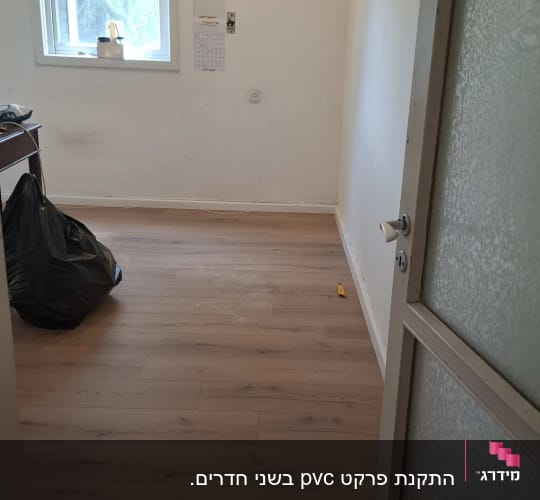רצפת פרקט בחדר ריק עם חלון ודלת פתוחה